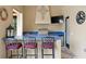Outdoor kitchen with blue tile countertop, stainless steel grill, and bar seating at 7713 Still Lakes Dr, Odessa, FL 33556