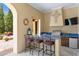 Outdoor kitchen with stainless steel grill, sink, and bar seating offering a great space for entertaining guests at 7713 Still Lakes Dr, Odessa, FL 33556
