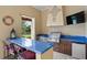 Outdoor kitchen boasts blue tiled counters, stainless grill, sink, mini-fridge, and TV for great outdoor experience at 7713 Still Lakes Dr, Odessa, FL 33556