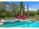 Inviting pool area featuring a spa, lounge chairs, and lush landscaping for a relaxing outdoor experience at 7713 Still Lakes Dr, Odessa, FL 33556