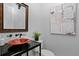 Stylish powder room with unique sink, black countertop, and modern art at 7713 Still Lakes Dr, Odessa, FL 33556