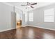 Bedroom view including ensuite bathroom, hardwood floor, ceiling fan, and neutral color walls at 7725 Tangle Rush Dr, Gibsonton, FL 33534