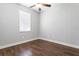 Bedroom featuring hardwood floors, a ceiling fan, and a large window at 7725 Tangle Rush Dr, Gibsonton, FL 33534
