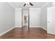 Bedroom features hardwood flooring, a ceiling fan, and doorway to an adjacent room at 7725 Tangle Rush Dr, Gibsonton, FL 33534