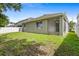 Rear exterior view of house with screened lanai and green lawn at 7725 Tangle Rush Dr, Gibsonton, FL 33534