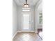 Warm foyer with decorative tile flooring, elegant lighting fixture and decorative glass front door at 7725 Tangle Rush Dr, Gibsonton, FL 33534