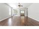Spacious living room featuring hardwood floors, ceiling fan, and sliding glass doors to a screened patio at 7725 Tangle Rush Dr, Gibsonton, FL 33534