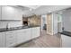 Kitchen featuring white cabinets, granite countertops, subway tile backsplash, and access to other rooms at 920 Virginia St # 109, Dunedin, FL 34698