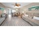 Open concept living room featuring ceiling fan, wood-look floors and adjoining kitchen at 920 Virginia St # 109, Dunedin, FL 34698
