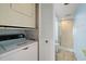 Compact laundry area with a stacked washer and dryer next to a bathroom at 9415 Blind Pass Rd # 1201, St Pete Beach, FL 33706