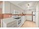 This kitchen features white cabinets, white appliances and light countertops at 9415 Blind Pass Rd # 1201, St Pete Beach, FL 33706