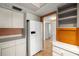 A modern kitchen with white appliances, cabinets, and access to the rest of the house at 9415 Blind Pass Rd # 1201, St Pete Beach, FL 33706