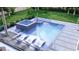 Stunning backyard oasis with a modern pool, spa, sleek lounge chairs, and lush landscaping creating a private retreat at 944 31St Ne Ter, St Petersburg, FL 33704