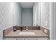 Well-lit half-bathroom featuring a modern sink, vanity, and geometric wallpaper at 100 1St N Ave # 2207, St Petersburg, FL 33701