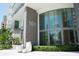 Modern building entrance with silver address numbers, large windows, and manicured hedges at 100 1St N Ave # 2207, St Petersburg, FL 33701