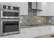 Close-up of modern kitchen appliances and a unique backsplash, adding style and sophistication at 100 1St N Ave # 2207, St Petersburg, FL 33701