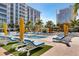 Relaxing community pool area with lounge chairs, umbrellas, and palm trees under a sunny sky at 100 1St N Ave # 2207, St Petersburg, FL 33701