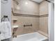 Bathtub with shower head features beautiful tile work and updated hardware and fixtures at 100 Bluff View Dr # 404C, Belleair Bluffs, FL 33770