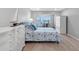 Bright bedroom with nautical decor, light wood floors, and sliding glass doors at 100 Bluff View Dr # 404C, Belleair Bluffs, FL 33770