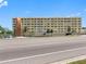 Exterior shot of a multi-story tan building featuring palm trees and lush landscaping at 100 Bluff View Dr # 404C, Belleair Bluffs, FL 33770