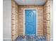 Striking blue front door with detailed design, framed by textured brick and contrasting flooring at 100 Bluff View Dr # 404C, Belleair Bluffs, FL 33770