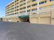 Exterior shot of multiple garage doors in a multi-story tan building, sunny day at 100 Bluff View Dr # 404C, Belleair Bluffs, FL 33770
