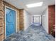 Long hallway with a distinctive blue carpet design, leading past brick accents and well-lit interiors at 100 Bluff View Dr # 404C, Belleair Bluffs, FL 33770