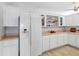 Bright kitchen with white cabinets, modern appliances, and natural light with open shelving to display decor at 100 Bluff View Dr # 404C, Belleair Bluffs, FL 33770