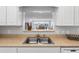 Bright kitchen with a breakfast bar that opens to a living room with views, stainless steel sink and faucet at 100 Bluff View Dr # 404C, Belleair Bluffs, FL 33770