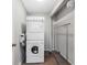 Compact laundry room features a stacked washer and dryer unit and convenient storage shelving at 100 Bluff View Dr # 404C, Belleair Bluffs, FL 33770