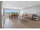 Open-concept living and dining area with light wood floors, a large window, and comfortable seating at 100 Bluff View Dr # 404C, Belleair Bluffs, FL 33770