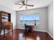A brightly lit office with wood floors, built-in desk, water view, and adjacent room with dolphin art at 100 Bluff View Dr # 404C, Belleair Bluffs, FL 33770