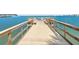 Picturesque pier view with benches along a wooden walkway, overlooking a clear ocean view at 100 Bluff View Dr # 404C, Belleair Bluffs, FL 33770