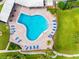 Aerial view of the Kidney-shaped pool with lounge chairs and brick paver decking at this property at 100 Bluff View Dr # 404C, Belleair Bluffs, FL 33770