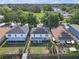 Aerial view of the houses with solar panels on the roof, a well-kept lawn, and mature landscaping at 10337 River Bream Dr, Riverview, FL 33569