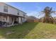 Large backyard with a covered patio, lush green grass, and a wooden fence at 10337 River Bream Dr, Riverview, FL 33569