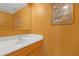 Half bathroom with a white sink, wooden vanity, mirror, and orange walls at 10337 River Bream Dr, Riverview, FL 33569