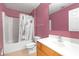 Bathroom with a shower-tub combo and a cherry wood vanity with a white sink at 10337 River Bream Dr, Riverview, FL 33569