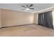 Bedroom with a ceiling fan and a large window covered by black curtains at 10337 River Bream Dr, Riverview, FL 33569