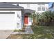 A close-up of a red front door with storm door, sidelight, and manicured yard at 10337 River Bream Dr, Riverview, FL 33569