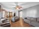 Open-concept living room featuring hardwood floors and grey couches leading to the kitchen at 10337 River Bream Dr, Riverview, FL 33569