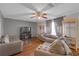 Open-concept living room featuring hardwood floors, gray couches, and a ceiling fan at 10337 River Bream Dr, Riverview, FL 33569