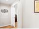 Hallway view with open door leading to bedroom, featuring wood floors and neutral walls at 10536 Shady Preserve Dr, Riverview, FL 33579