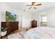 Bedroom with wood floors, a ceiling fan, large TV, and connecting bathroom at 10536 Shady Preserve Dr, Riverview, FL 33579