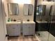 Bathroom featuring dual vanities, sleek fixtures, and a walk-in shower with hexagon tile at 10826 Rain Lilly Pass, Land O Lakes, FL 34638