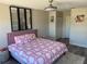 Comfortable bedroom with a plush pink bed frame, mirrored wall art and wood laminate flooring throughout at 10826 Rain Lilly Pass, Land O Lakes, FL 34638