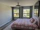Bright bedroom features a plush pink bed frame, modern ceiling fan, and large windows for plenty of natural light at 10826 Rain Lilly Pass, Land O Lakes, FL 34638