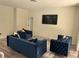 Living room featuring comfortable blue seating, a modern white brick wall, and natural lighting at 10826 Rain Lilly Pass, Land O Lakes, FL 34638