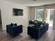 Bright living room with comfortable blue seating and a view of the outdoors at 10826 Rain Lilly Pass, Land O Lakes, FL 34638
