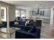 Open-concept living room with a kitchen in the background and modern blue seating at 10826 Rain Lilly Pass, Land O Lakes, FL 34638
